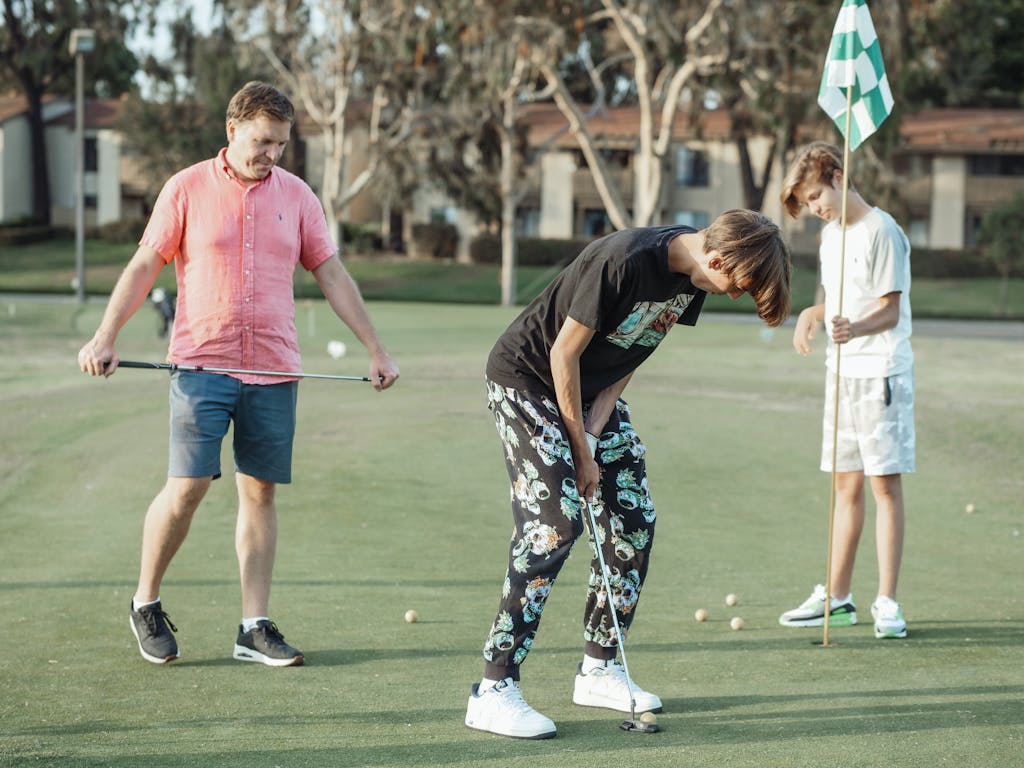 Group of three friends enjoying a casual golf game on a sunny day.